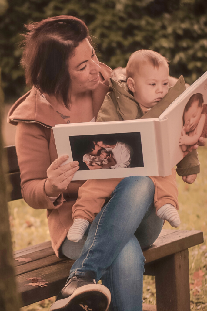 Mother and baby with a layflat baby photo album with a photo cover